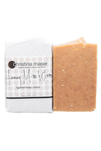 Load image into Gallery viewer, Honey Milk and Oats bar soap. Soap is a rich brown color with oat flecks. Wrapped in white paper with label with beige dot accents.