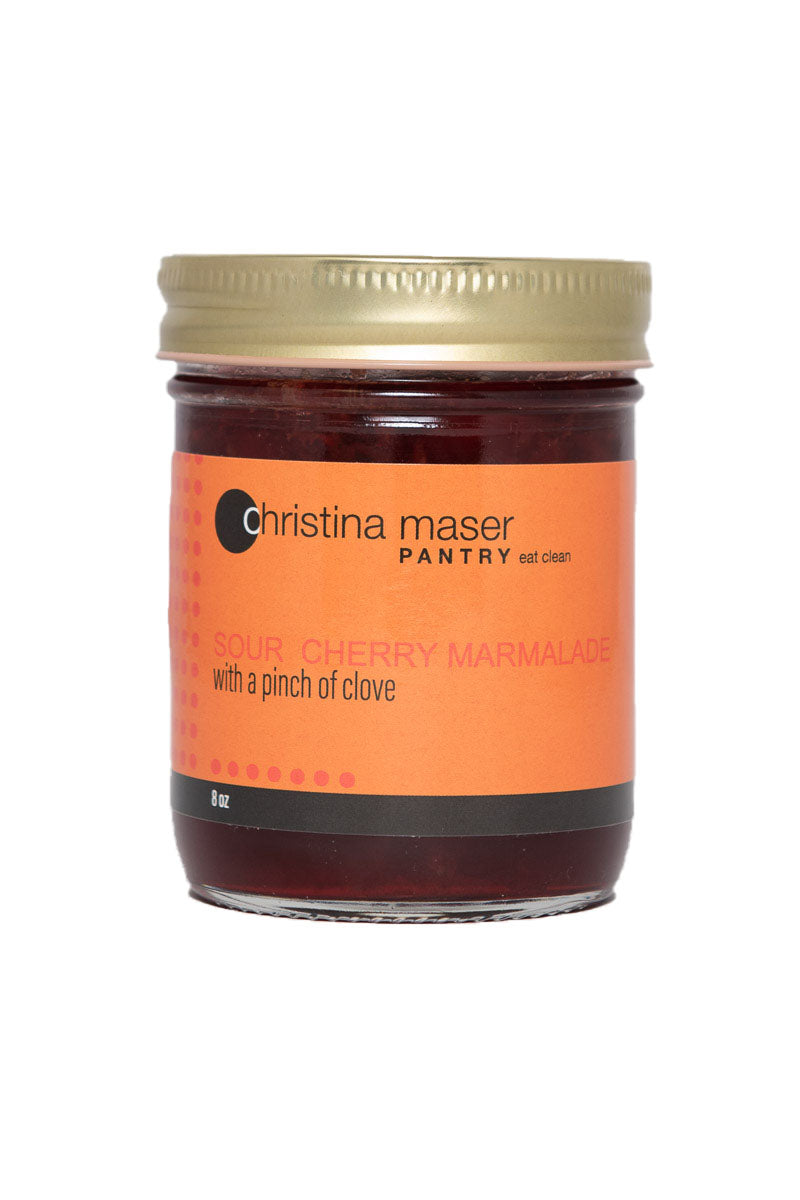 Sour Cherry marmalade jam with clove in clear glass mason jar with orange wraparound label.