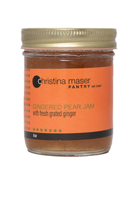 Gingered Pear jam in a clear glass mason jar with orange wrap-around label with pale green accents.