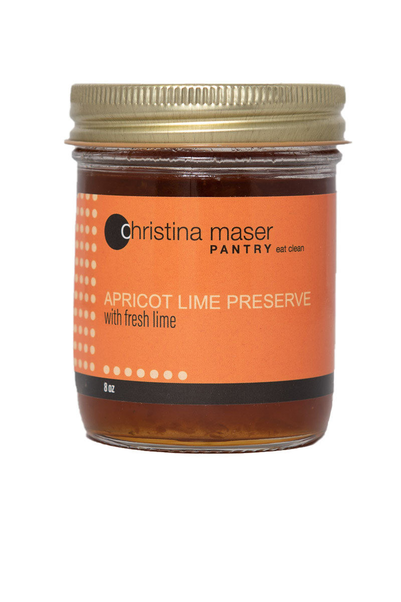 Photo of Apricot Lime Preserve organic jam in a glass mason jar with orange wraparound label.