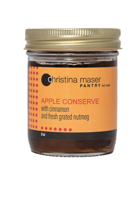 Photo of Apple Conserve organic jam in a glass mason jar with orange wrap label.
