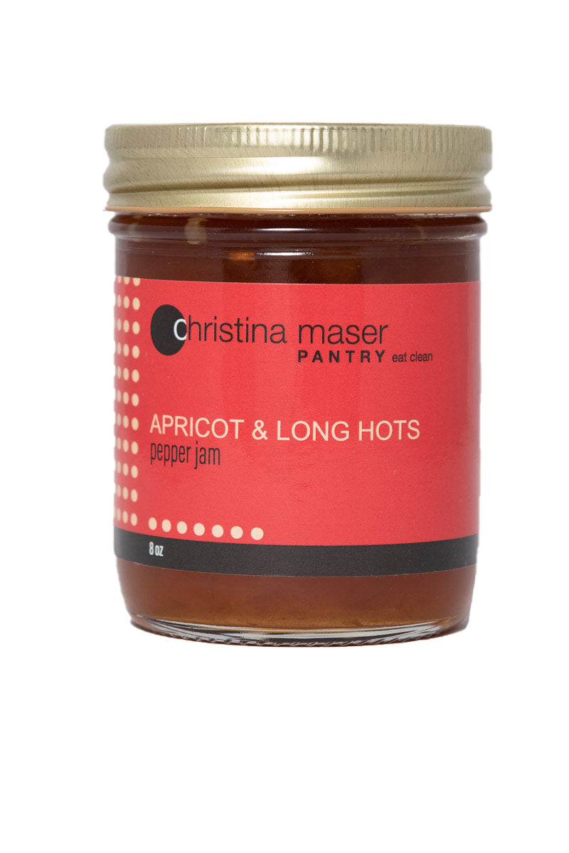 Photo of Apricot and Long Hots Pepper Jam in a glass mason jar with a red wraparound label.