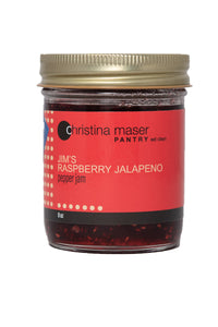Good Food Award winning Raspberry Jalapeno Pepper Jam in clear glass jar with red wraparound label. Made with local peppers and organic cane sugar.