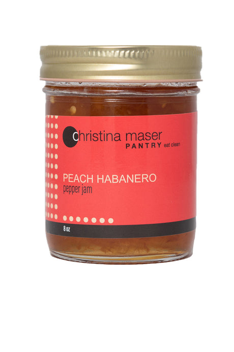 Peach Habanero pepper jam in clear glass mason jar with red wraparound label.