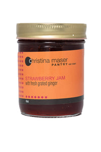 Strawberry ginger jam in clear glass mason jar with orange label.
