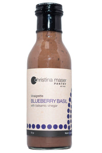 Blueberry Basil Vinaigrette in a tall glass bottle with a tan label with indigo colored accents.