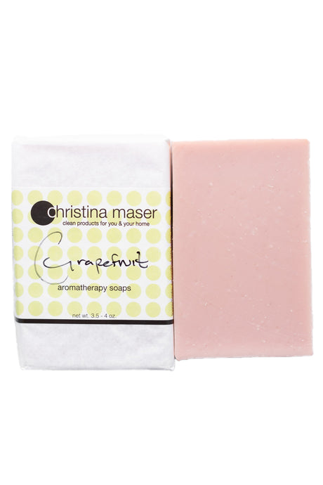 Grapefruit vegan bar soap. Soap is a pale pink and wrapped in white paper with label with light green dot accents.
