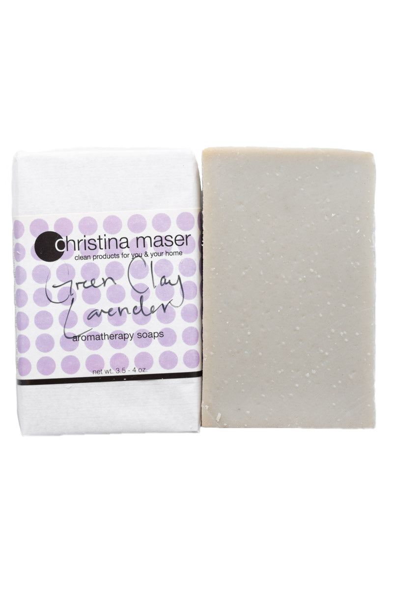 Green Clay lavender vegan bar soap. Handmade soap is slate grey. Bar is wrapped in white paper with lavender colored dot accents on the label.
