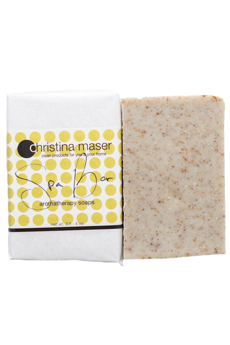 Spa Bar vegan bar soap. Speckled rectangular bar soap wrapped in white paper with green dot accents.