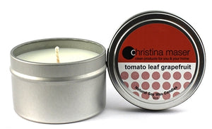 tomato leaf grapefruit soy wax candle in silver metal tin with lid featuring red label.